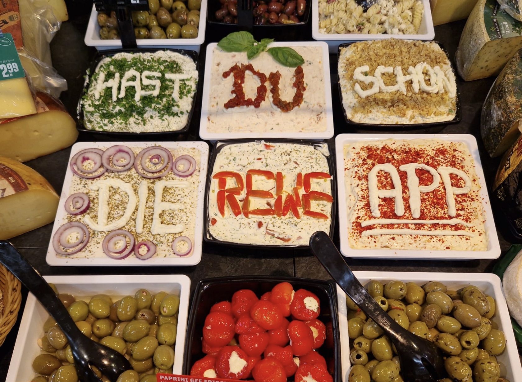 Salat dekoriert mir dem Worten: "Hast du schon die REWE App?"